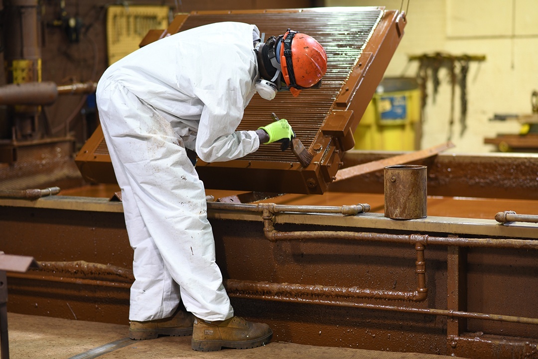 Man Coating Metal with Brush