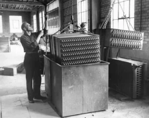 Black and White Photo of workers dipping coils